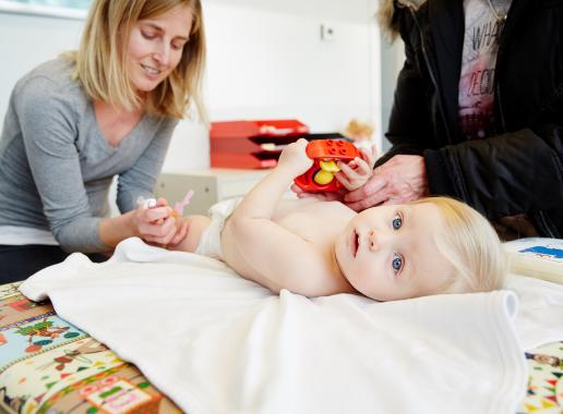 Arts geeft vaccinatie in been van baby